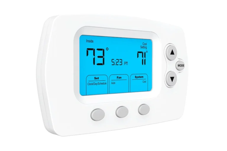 White digital thermostat displaying an inside temperature of 73°F, a cooling setting of 71°F, and the time as 5:23 PM, with buttons for mode and setting adjustments.